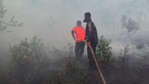 PADAMKAN API. Petugas memadamkan api yang melahap lahan dekat perumahan warga. (Rapal JKN - Hello Borneo)
