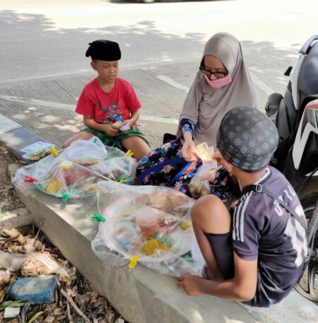 Ibnu dan devan bocah kelas 5 SD saat melayani pembeli yang hasil jualannya untuk beli HP. (R Zulkarnain F - Hello Borneo)