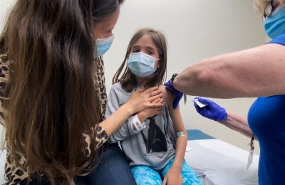 Marisol Gerardo, 9, digendong ibunya saat mendapatkan dosis kedua vaksin Pfizer selama uji klinis untuk anak-anak di Duke Health di Durham, North Carolina, AS, 12 April 2021. (Foto: via Reuters)