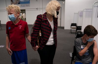 Dua remaja AS menunggu bersama ibu mereka untuk mendapatkan vaksin COVID-19 di Santa Ana, California (foto: dok).