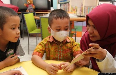 Seorang relawan Yayasan Onkologi Anak Indonesia (YOAI) bermain bersama anak-anak yang sedang menjalani perawatan kanker, September 2019. (Foto: Yayasan Onkologi Anak Indonesia)