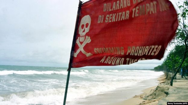 Bendera peringatan berkibar saat gelombang tinggi mencapai pantai sebagai ilustrasi. BMKG BMKG) mengeluarkan peringatan dini potensi lahirnya siklon tropis di sekitar Samudera Hindia, Barat Daya Lampung. (Foto: AFP/Sonny Tumbelaka)
