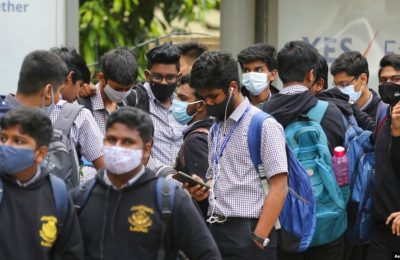Para siswa di Bengaluru, India, menggunakan masker sebagai langkah pencegahan penularan COVID-19 saat mereka menunggu bis sekolah yang akan datang menjemput pada 30 November 2021. (Foto: AP/Aijaz Rahi)