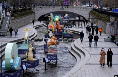 Orang-orang mengenakan masker saat berjalan-jalan di tengah pandemi COVID-19 di Seoul, Korea Selatan, Kamis, 2 Desember 2021.