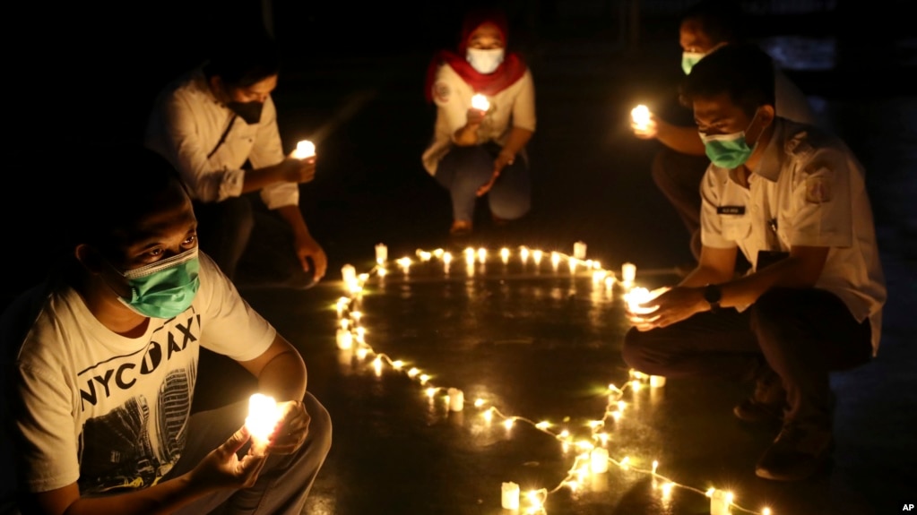 Aktivis Indonesia memegang lilin dalam rangka memperingati Hari AIDS Sedunia di Jakarta, Rabu, 1 Desember 2021. Hari AIDS Sedunia diperingati pada 1 Desember setiap tahun untuk meningkatkan kesadaran tentang AIDS. (Foto AP/Tatan Syuflana)