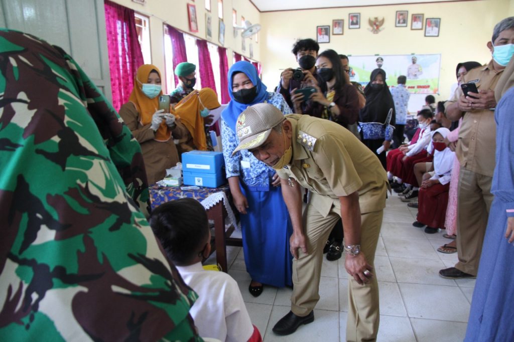 Plt Bupati Penajam Paser Utara, Hamdam Pangrewa menyapa siswa sekolah dasar dalam kegiatan vaksinasi usia 6-11 tahun di daerah itu, Senin (17/01) (ESY)