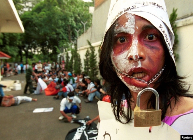 Seorang aktivis pelajar Indonesia mengikat mulutnya untuk melambangkan kurangnya kebebasan berbicara saat melakukan protes di depan kantor Komisi Hak Asasi Manusia di Jakarta Pusat. (Foto: Reuters)