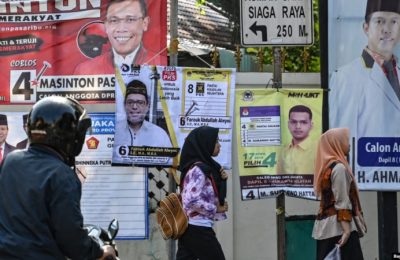 Pejalan kaki melewati spanduk kampanye Pemilu 2019 di Jakarta.(Foto: AFP/Bay Ismoyo)