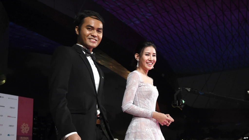 Sutradara film Penyalin Cahaya Wregas Bhanuteja (kiri) dan pemeran utama film tersebut Shenina Cinnamon tiba di karpet merah Festival Film Busan ke-26 di Busan Cinema Center, pada 6 Oktober 2021. (Foto: AFP/Jung Yeon-je)