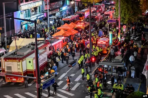 Polisi dan paramedis berkumpul untuk membantu puluhan orang mengaami serangan jantung, di distrik Itaewon di Seoul pada 30 Oktober 2022. (Foto: AFP)