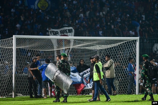 TNI dan Polri mengamankan lapangan usai pertandingan sepak bola Arema FC melawan Persebaya Surabaya di Stadion Kanjuruhan Malang, Jawa Timur (Foto: AFP)