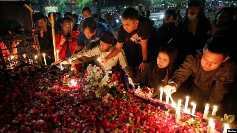 Suporter klub sepak bola Arema menyalakan lilin di luar stadion Kanjuruhan untuk menyampaikan belasungkawa kepada para korban pasca kerusuhan di Stadion Kanjuruhan, Malang, Jawa Timur, Minggu 2 Oktober 2022.