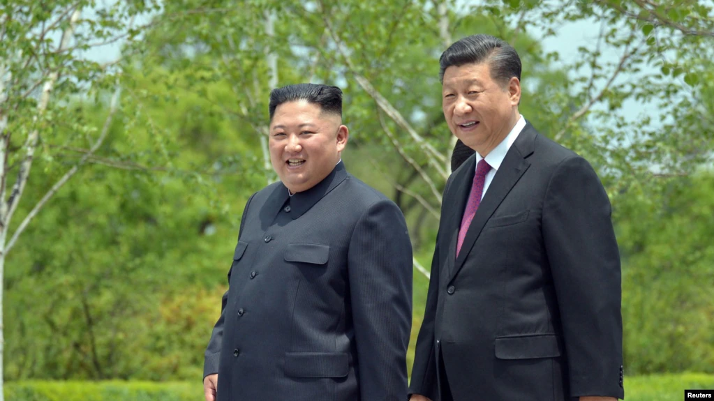 Presiden China Xi Jinping dan pemimpin Korea Utara Kim Jong Un berjalan selama kunjungan Xi di Pyongyang, Korea Utara. (Foto: Reuters)