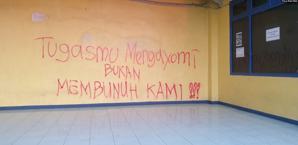 Bentuk protes suporter atas sikap represif aparat tertulis pada tembok stadion Kanjuruhan di Malang, Jawa Timur, pada 4 Oktober 2022. (Foto: VOA/Petrus Riski)