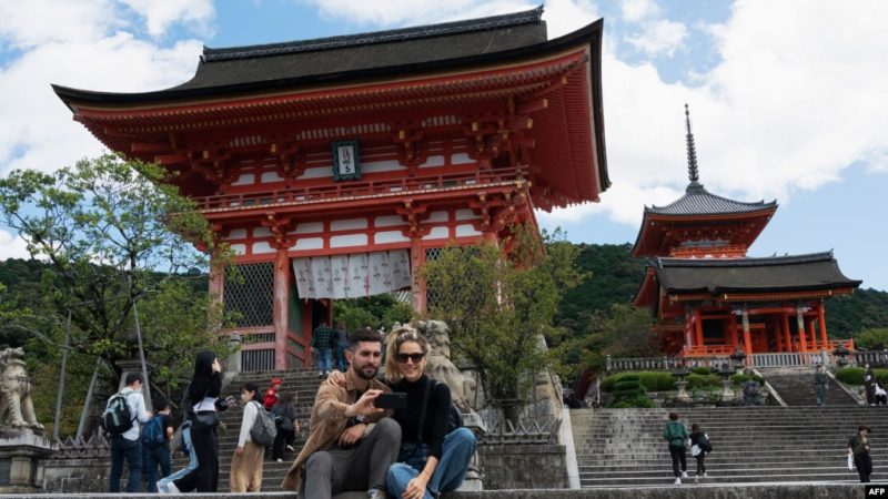 Wisatawan berfoto selfie di dekat pintu masuk kuil Kiyomizu-dera di Kyoto pada 11 Oktober 2022. (Fred MERY / AFP)