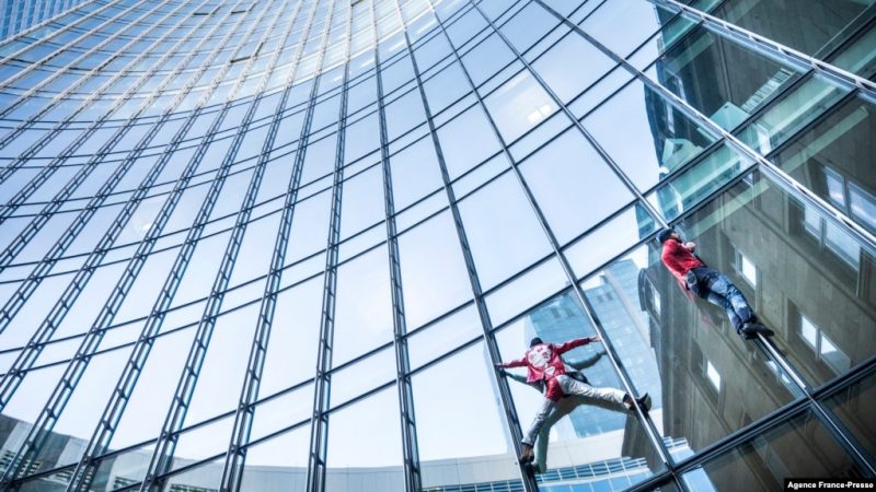 Alain Robert (kiri), yang dikenal sebagai "Spiderman Prancis", dan Leo Urban memanjat gedung Menara SKYPER setinggi 153,8 meter di Frankfurt am Main, Jerman barat pada 23 November 2021. (Foto: AFP )