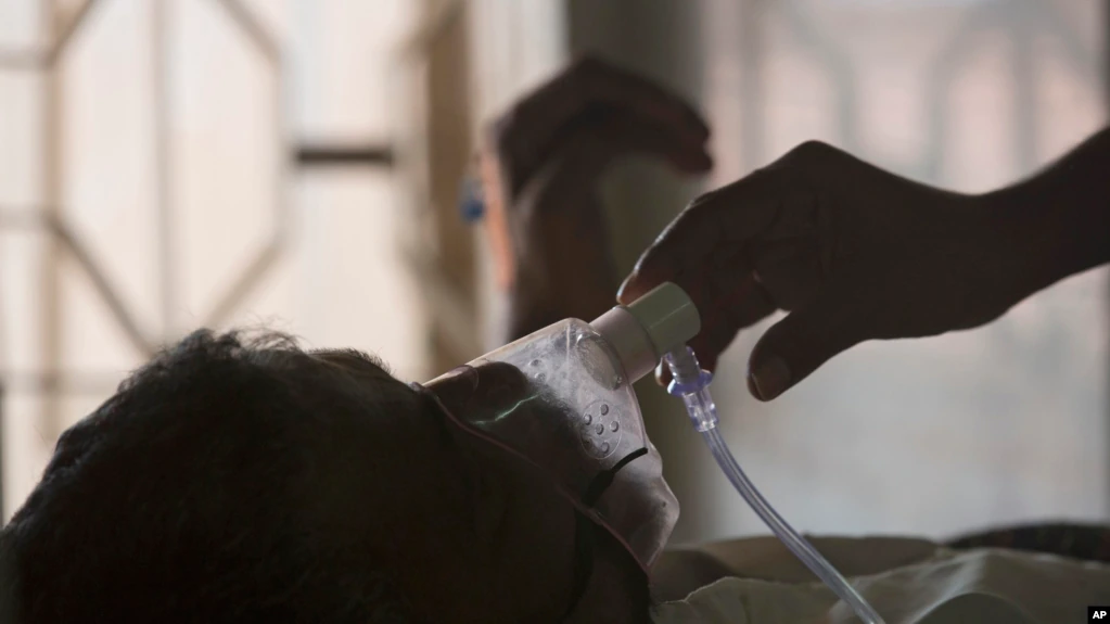 FILE - Seorang kerabat menyesuaikan masker oksigen pasien tuberkulosis di rumah sakit TB pada Hari Tuberkulosis Sedunia di Hyderabad, India, Sabtu, 24 Maret 2018.