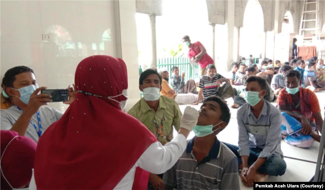 Petugas medis melakukan pemeriksaan terhadap ratusan orang etnis Rohingya yang terdampar di pesisir pantai Meunasah Lhok, Kecamatan Muara Batu, Kabupaten Aceh Utara, Provinsi Aceh, Selasa 15 November 2022. (Courtesy: Pemkab Aceh Utara)