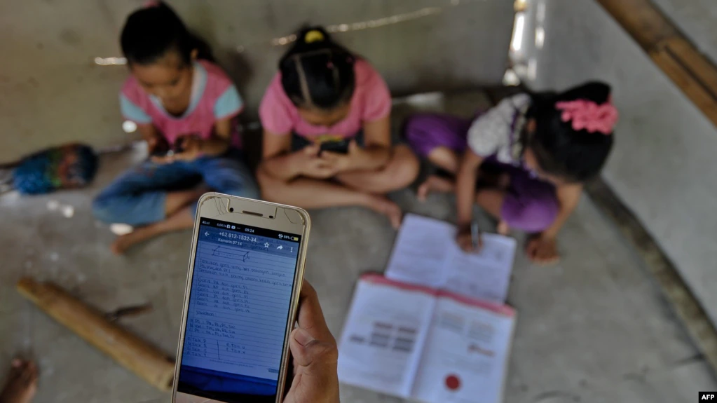 Ilustrasi - Murid-murid SD di desa bukit Temulawak, Yogyakarta, sedang belajar secara online menggunakan ponsel pintar, 8 Mei 2020. (Foto: AFP)