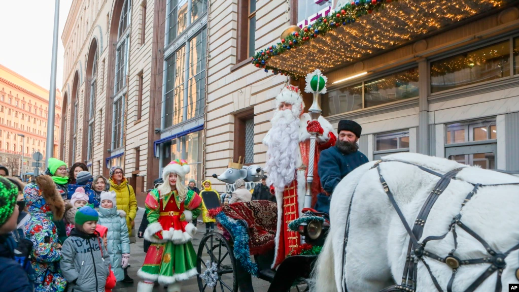 Seorang aktor berpakaian Ded Moroz (Sinterklas) atau Pastor Frost, menyapa anak-anak saat ia tiba di Toko Anak Pusat di Moskow, Rusia, Minggu, 4 Desember 2022. (Sofia Sandurskaya, Foto Kantor Berita Moskow via AP)