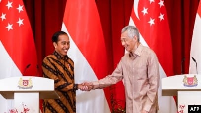 Perdana Menteri Singapura Lee Hsien Loong (kanan) dan Presiden Indonesia Joko Widodo (kiri) dalam konferensi pers bersama di Istana Singapura, 16 Maret 2023. (EDGAR SU/POOL/AFP)