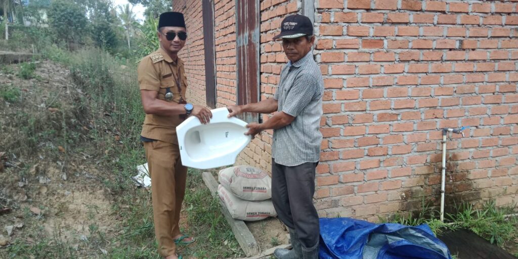 Lurah Maluhu Tri Joko Kuncoro saat memberikan bantuan Water Closet kepada masyarakat. (Ist)