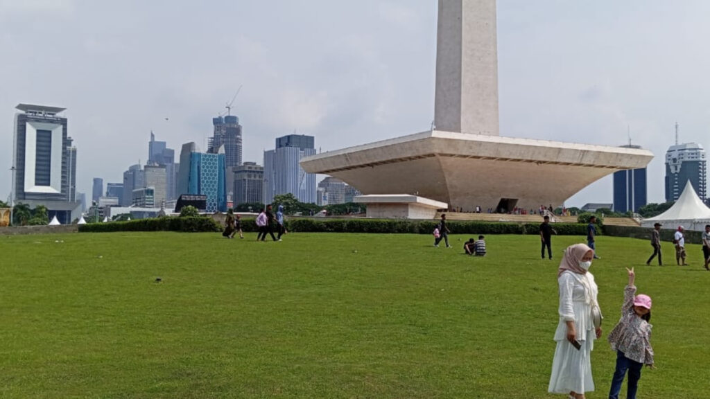 Seorang ibu dan anak yang sedang berfoto di Monumen Nasional (Monas) pada Libur Lebaran 1445 H