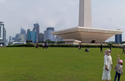 Seorang ibu dan anak yang sedang berfoto di Monumen Nasional (Monas) pada Libur Lebaran 1445 H