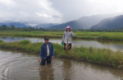 Runtu Lemba Tumatio (57) berdiri diatas lahan sawah miliknya yang terendam air danau di Desa Toinasa, Kecamatan Pamona Barat, Minggu (3/10/2021). (Foto: VOA/Yoanes Litha)