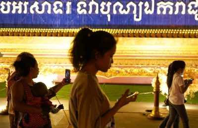 Sejumlah orang berjalan sambil menggunakan ponsel mereka di Phnom Penh, Kamboja, 18 Februari 2021. (Foto: Reuters)