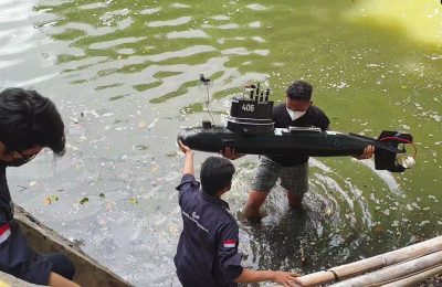 Sekelompok mahasiswa Universitas Sebelas Maret (UNS) Solo melakukan uji coba drone kapal selam buatan mereka di area danau kampus pada 18 Oktober 2021. (Foto: VOA/Yudha Satriawan)