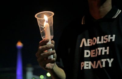 Seorang aktivis memegang lilin dalam aksi protes menentang hukuman mati di luat Istana Presiden, Jakarta, 28 Juli 2016. (Foto:ilustrasi/AP Photo/Dita Alangkara)