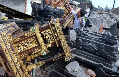 Seorang pria terlihat di antara bangunan pura yang rusak setelah gempa berkekuatan 4,8 melanda timur laut Bali, di Karangasem, Bali, 16 Oktober 2021, (Foto: Antara/Fikri Yusuf via REUTERS)