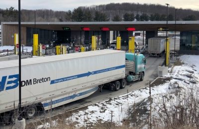 Truk dari Canada menunggu saat akan melintasi perbatasan menuju Amerika Serikat di Derby Line Vt, 18 Maret 2020. AS akan membuka kembali perbatasan ini bulan November mendatang, setelah ditutup akibat pandemi COVID-19. (AP Photo/Wilson Ring).