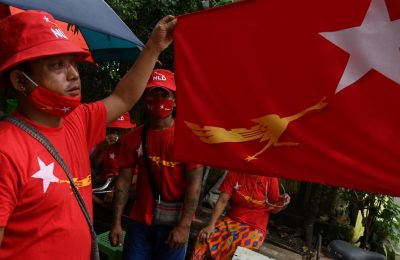 Pendukung partai Liga Nasional untuk Demokrasi (NLD) mengibarkan bendera Myamnar di Yangon pada 8 September 2020. Myanmar melewatkan KTT ASEAN setelah jenderal pemimpin dilarang menghadiri pertemuan itu. (Foto: AFP/Ye Aung Thu)