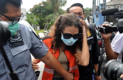 Heather Mack (tengah) digiring oleh petugas imigrasi menuju kantor imigrasi di Jimbaran, Bali, sesaat setelah dibebaskan dari penjara pada 29 Oktober 2021. (Foto: AFP/Sonny Tumbelaka)