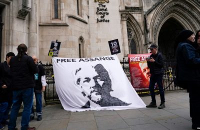 Sebuah spanduk yang bertuliskan dukungan terhadap pendiri WikiLeaks Julian Assange dipasang di luar gedung Pengadilan Tinggi London, pada 23 Oktober 2021. Spanduk tersebut dibentangkan menjelang pengadilan kasus ekstradisi Assange. (Foto: AP/Alberto Pezzali)