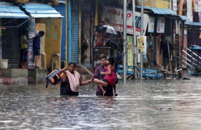 Sebuah keluarga mengarungi jalan yang tergenang banjir di Chennai, India, Rabu, 25 November 2020. Pada 19 November 2021, pihak berwenang negara bagian Andhra Pradesh, India mengatakan sedikitnya 17 orang tewas dan puluhan dilaporkan hilang setelah hujan lebat. (Foto: AP)