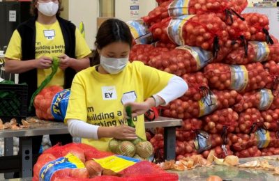 Seorang sukarelawan mengemas bawang di gudang Bank Makanan Komunitas Alameda County di Oakland, California, 5 November 2021. (AP/Terry Chea)