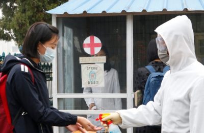 Seorang siswa perempuan yang memakai masker membersihkan tangannya dengan cairan pembersih sebelum memasuki area Sekolah Menengah Pertama Kumsong di Pyongyang, Korea Utara, pada 3 November 2021. (Foto: AP/Cha Song Ho)