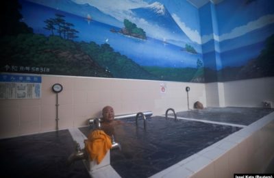 Orang-orang berendam di bak mandi dengan lukisan Gunung Fuji di dinding pemandian umum Jepang, atau sento, 'Dai-ni Takara-yu' di Tokyo, Jepang 25 November 2021. (Foto: REUTERS/Issei Kato)