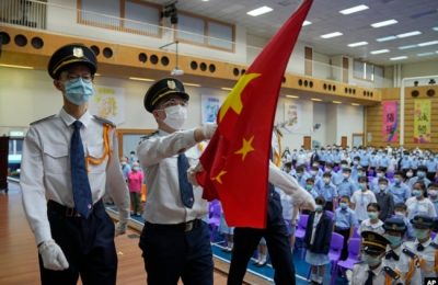 Siswa mengenakan masker untuk membantu mencegah penyebaran virus COVID-19, menghadiri upacara pengibaran bendera nasional China pada hari pertama tahun ajaran baru di sekolah menengah, di Hong Kong, Rabu, 1 September 2021.