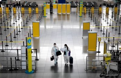 Penumpang yang mengenakan hazmat berjalan melalui Bandara Internasional Ninoy Aquino di Paranaque, Metro Manila, Filipina. (Foto: Reuters)