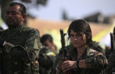 Seorang anggota Pasukan Demokratik Suriah (SDF) memegang senjatanya saat kelompok tersebut mengumumkan perebutan wilayah ladang minyak al-Omar di Deir Al Zor, Suriah, yang sebelumnya dikuasai oleh kelompok ISIS, pada 23 Maret 2019. (Foto: Reuters/Rodi Said)