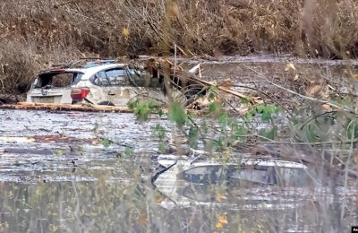 Dua kendaraan di tengah puing-puing di ​Highway 7, di barat Agassiz, British Columbia, Kanada, Sabtu, 20 November 2021.