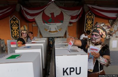 Petugas pemilihan mengenakan pakaian adat Papua saat pemilihan di TPS 17 April 2019. (Foto: Antara/Nyoman Hendra Wibowo via Reuters)