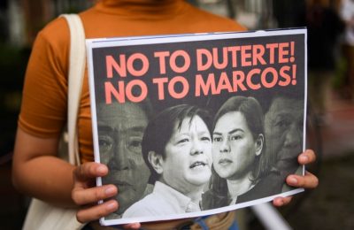 Seorang demonstran memegang poster saat protes pencalonan presiden Ferdinand “Bongbong” Marcos Jr., putra mendiang diktator Ferdinand Marcos, di Komisi Hak Asasi Manusia, di Kota Quezon, Metro Manila, Filipina, 6 Oktober 2021 (Foto: Reuters)