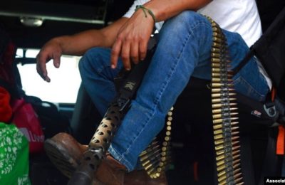 Seorang anggota kelompok pengamanan swakarsa yang dikenal dengan nama Pueblos Unidos duduk dengan amunisi dalam aksi protes di Nuevo Urecho, Michoacan, pada 27 November 2021. (Foto: AP)
