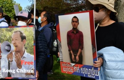 Para pengunjuk rasa memegang plakat pemimpin serikat pekerja Rong Chhun dan seorang pemuda yang ditangkap karena mengkritik pemerintah, 22 Oktober 2021. (Foto: VOA)