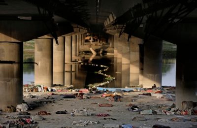 Tempat tidur dan barang-barang milik para pekerja migran dan tunawisma India tergeletak berserakan setelah mereka diusir dari tepi Sungai Yamuna saat diberlakukannya lockdown akibat pandemi COVID-19 di New Delhi, India, Rabu, 15 April 2020. (AP /Altaf Qadri)